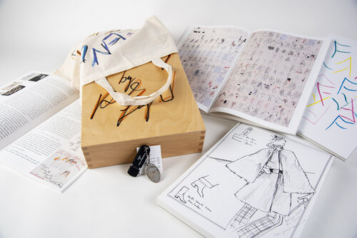 Poster, USB-Stick, Skizzen, Leinentasche und Holzkiste von Karl Lagerfeld