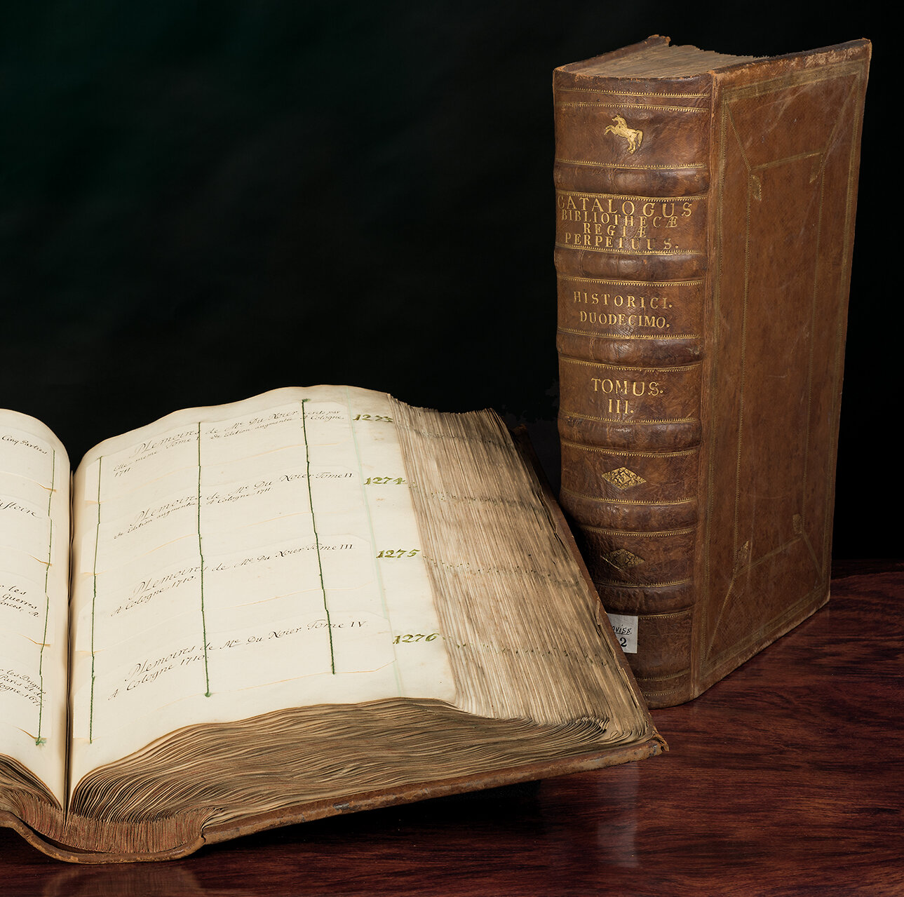 Catalogus perpetuum bibliotheca regiae © GWLB/Wollenberg Aufgeschlagener Catalogus perpetuum bibliotheca regiae mit Buch im Hintergrund